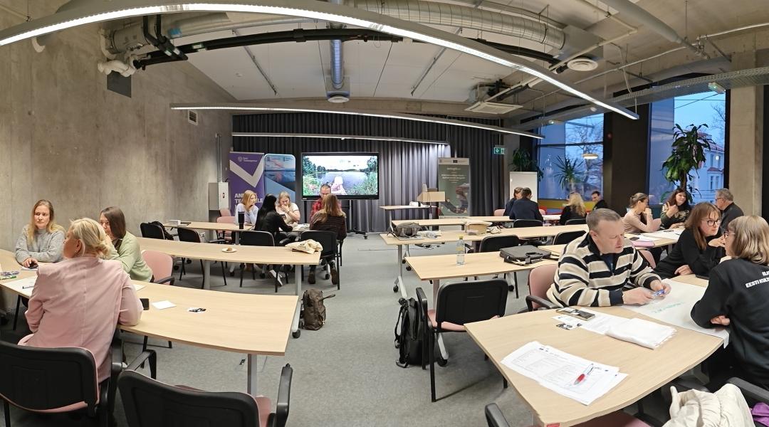 inimesed laudade taga seminariruumis